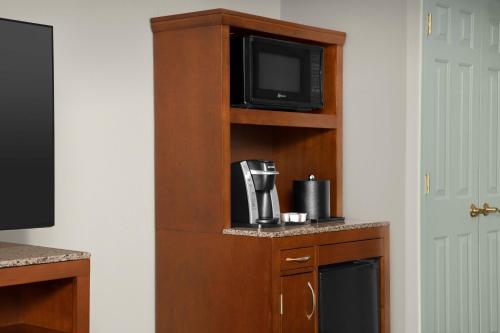 a book shelf with a tv and a coffee maker at Hilton Garden Inn Hoffman Estates in Hoffman Estates