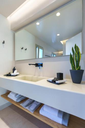 a bathroom with a sink and a large mirror at Halo Santorini - Living Experience in Fira