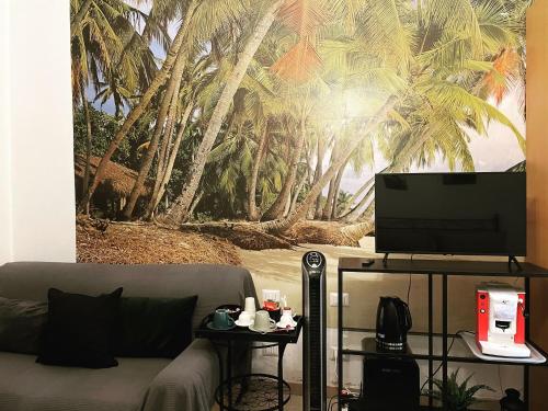 a living room with a couch and a palm tree mural at Da Alessia Per Dormire Al Coppedé in Rome