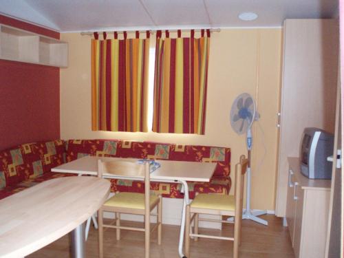 a dining room with a table and chairs and a window at Bungalows Land'shause in Pataias