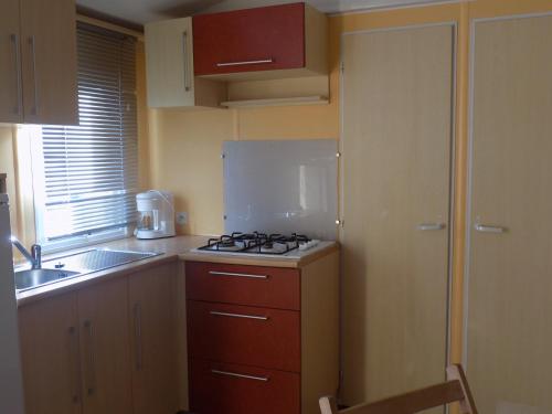 a small kitchen with a stove and a sink at Bungalows Land'shause in Pataias