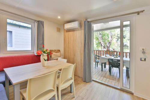 a dining room with a table and a balcony at Camping Village Le Calanchiole in Capoliveri