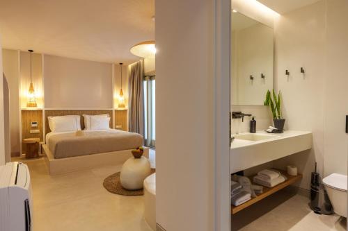 a bathroom with a bed and a sink in a room at Halo Santorini - Living Experience in Fira