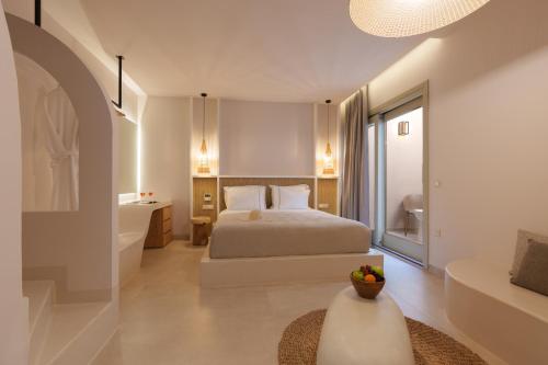 a bedroom with a bed and a bathroom with a tub at Halo Santorini - Living Experience in Fira