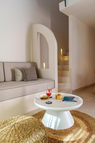 a living room with a couch and a table at Halo Santorini - Living Experience in Fira