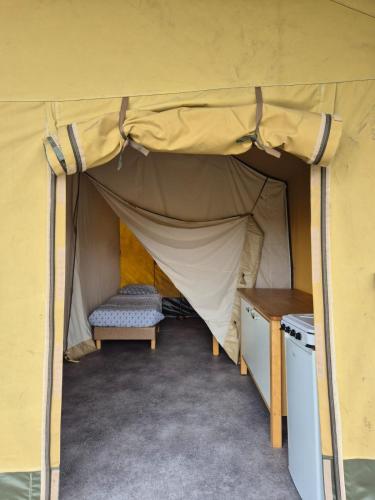 a tent with a bench and a table in it at La Bedure in Luzy