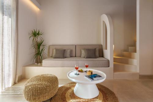 a room with a bed with a table and two glasses of wine at Halo Santorini - Living Experience in Fira