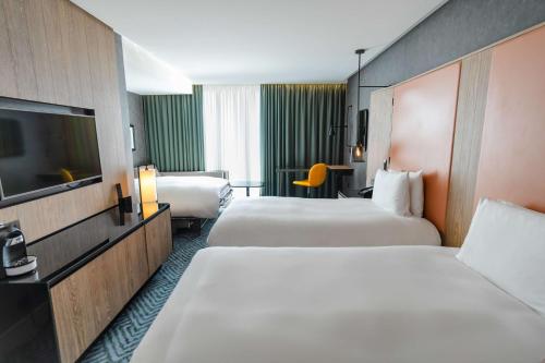 a hotel room with two beds and a flat screen tv at Hilton London Bankside in London