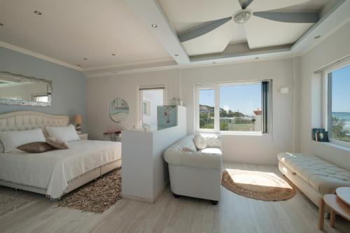 a bedroom with a bed and a couch at Margarita's Luxury Suites in Agios Stefanos