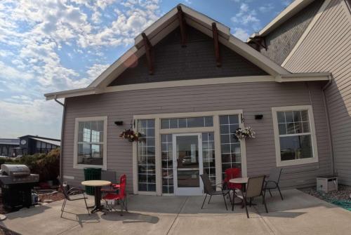 a patio with chairs and tables in front of a house at La Quinta by Wyndham Belgrade - Bozeman Airport in Belgrade