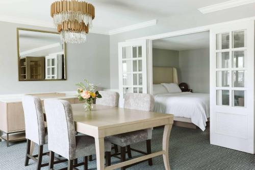 a dining room with a table and chairs and a bed at Seaview, A Dolce Hotel in Galloway