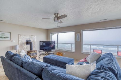 a living room with a blue couch and a tv at Casa de Navarro in Lincoln City