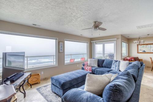 a living room with a blue couch and windows at Casa de Navarro in Lincoln City