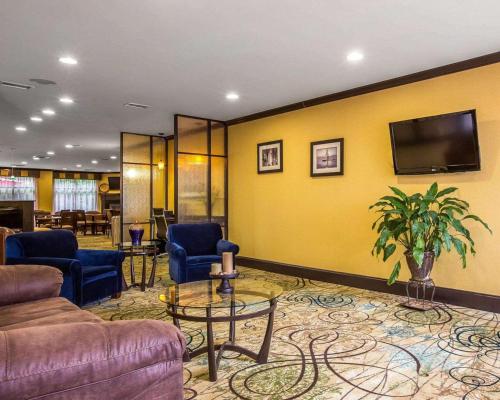 a lobby with couches and a tv on a yellow wall at Comfort Suites Simpsonville - Greenville in Simpsonville
