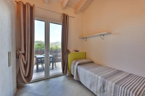 a bedroom with a bed and a balcony with a table at Camping Village Le Calanchiole in Capoliveri