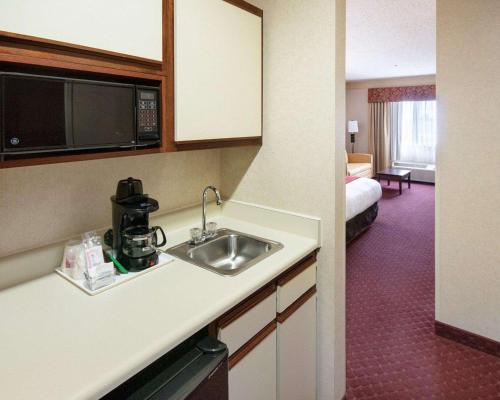 a kitchen with a sink and a room with a bed at Comfort Suites Parkersburg South in Mineralwells