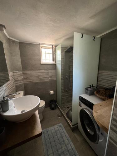 a bathroom with a sink and a toilet at Margarita cottage in Paralia Velikas in Messini