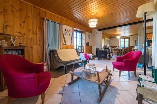 un salon avec des chaises rouges et une table dans l'établissement 200m chalet for 14 people with a panoramic view of the valley, à Albiez-le-Jeune