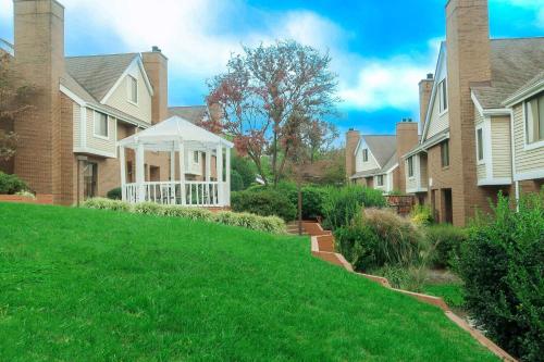 a lawn in front of a house with a gazebo at Tysons Corner Suites, A Baymont by Wyndham in Vienna