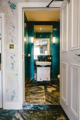 a bathroom with green walls and a white door at Baloci in Birmingham