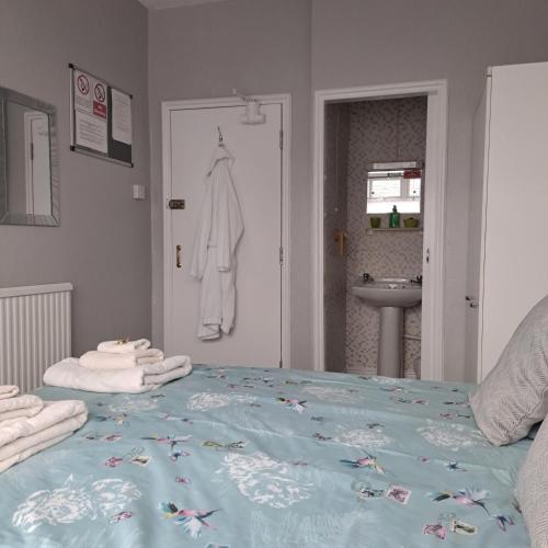 a bedroom with a bed with towels on it at The Sandgate in Skegness