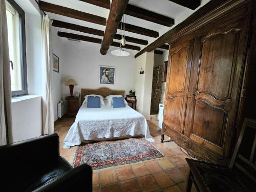 une chambre avec un lit avec des oreillers bleus dessus dans l'établissement Superbe Mas Provençal avec piscine au pied de Gordes, à Gordes