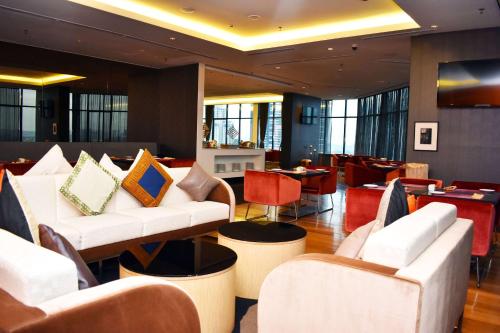 a lobby with white couches and chairs and tables at Wyndham Grand Bangsar Kuala Lumpur in Kuala Lumpur
