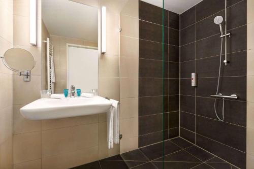 a bathroom with a sink and a shower at Wyndham Garden Munich Messe in Munich