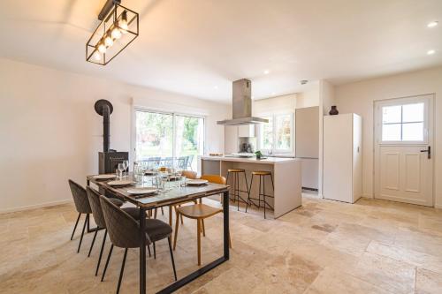 une cuisine et une salle à manger avec une table et des chaises dans l'établissement La Maison Des Roses, à Athis