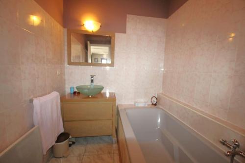 une salle de bain avec une baignoire et un lavabo et une baignoire dans l'établissement CASITA Appartement Climatisé F4 avec Terrasse et Garage, à Collioure