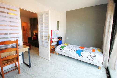 une chambre avec un lit, une table et un bureau dans l'établissement CASITA Appartement Climatisé F4 avec Terrasse et Garage, à Collioure