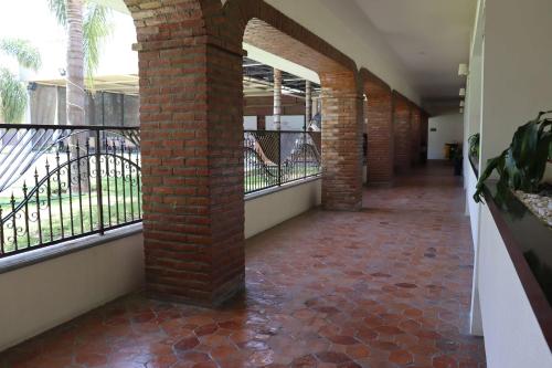 ein leerer Flur mit einer Backsteinsäule und Fenstern in der Unterkunft Wyndham Garden Aguascalientes Hotel & Casino in Aguascalientes