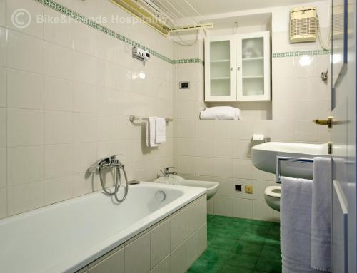 a white bathroom with a tub and a sink at Casa Alceo in Pesaro