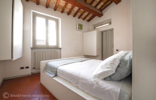 a white bed in a room with a window at Casa Alceo in Pesaro