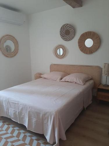 - une chambre avec un lit et deux miroirs sur le mur dans l'établissement Atelier d'artiste, au Muy