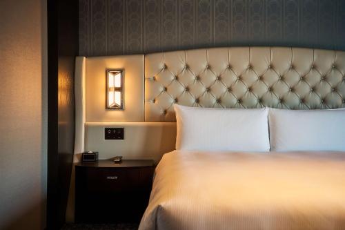 a hotel room with a bed and a night stand at Hilton Yokohama in Yokohama