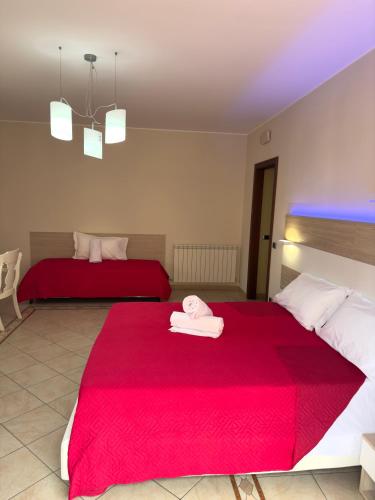 a bedroom with two beds with red sheets at Regina Margherita B&B in Amantea