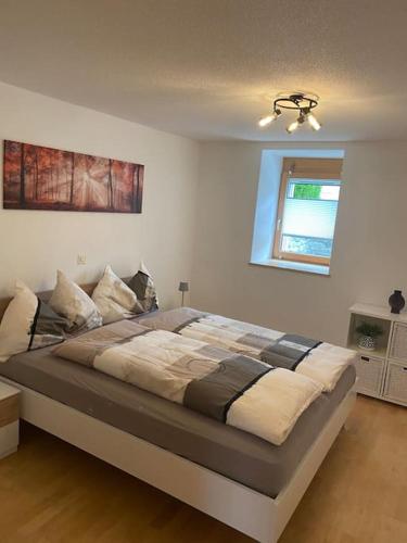 ein großes Bett in einem Schlafzimmer mit einer Decke in der Unterkunft Zentrale Wohnung in ruhiger Lage in Baltschieder in Baltschieder