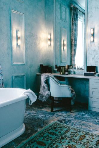 a blue bathroom with a tub and a sink at Baloci in Birmingham