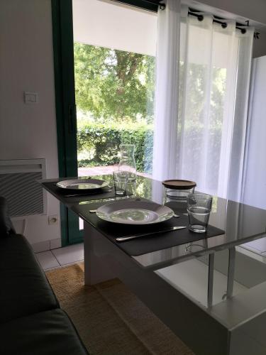 une cuisine avec une table avec des assiettes et des verres dessus dans l'établissement Aude, à La Rochelle