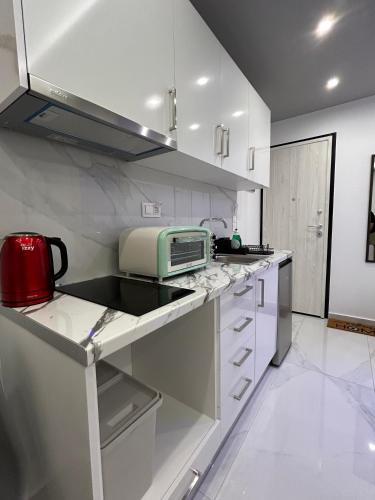 a kitchen with white cabinets and a microwave at Premium Studio DANAI 14 Paralia Beach in Paralia Katerinis