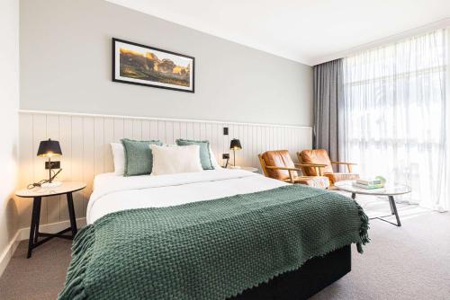 a bedroom with a large bed and two chairs at Econo Lodge Gateway Tamworth in Tamworth