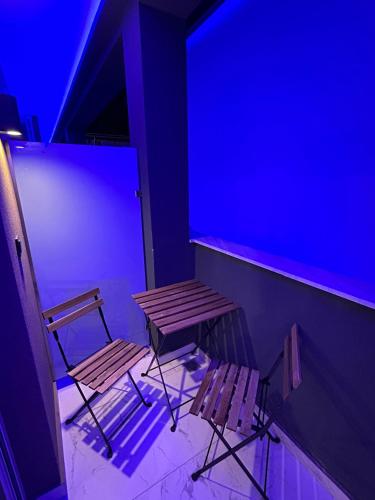 a bench and chair in a room with blue lights at Premium Studio DANAI 14 Paralia Beach in Paralia Katerinis