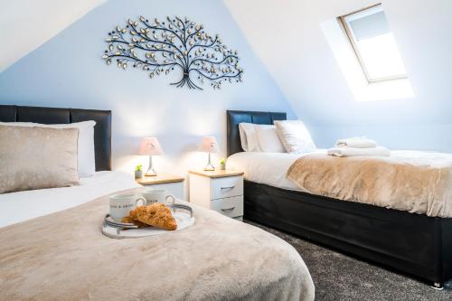 a bedroom with two beds with a tray of food on the bed at Progressive House 5 Bedrooms Inc Study with Sofabed, Garden, Smart TV in Every Bedroom FREE Parking in Peterborough