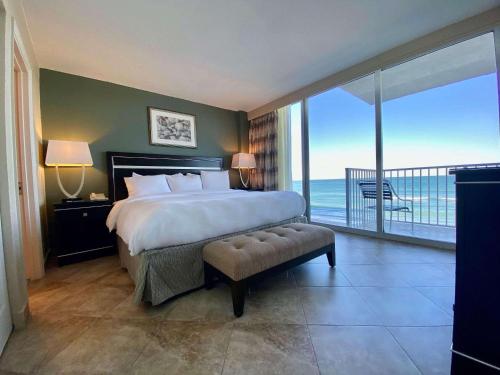 a bedroom with a bed and a view of the ocean at Radisson Suite Hotel Oceanfront in Melbourne