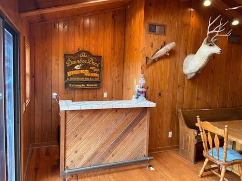 a cabin with a bar with a deer head on the wall at Triangle Ranch in Masaryktown