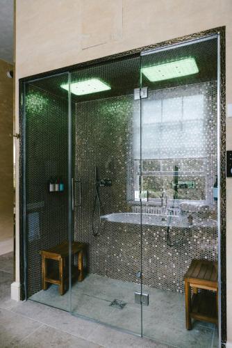 a glass shower with a tub in a room at Baloci in Birmingham