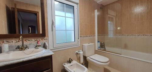 ein Badezimmer mit Waschbecken, Toilette und Spiegel in der Unterkunft Vivienda Vacacional El Cuetu del Sella in Llames de Pría