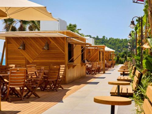 a row of chairs and tables on a patio at Mövenpick Resort Antalya Tekirova - Ultra All Inclusive in Tekirova