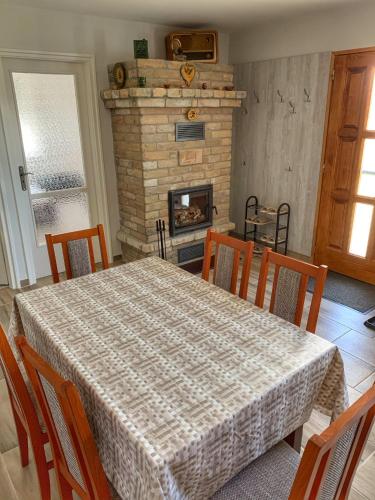 a dining room with a table and a fireplace at Boróka Vendégház Gerjen in Gerjen
